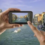 tourist holds up camera phone at the grand canal